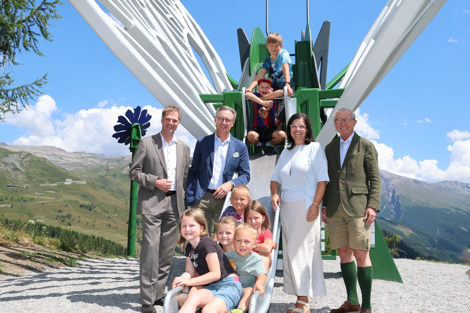 Martin Lackner (Bürgermeister Heiligenblut am Großglockner), Johannes Hörl (Vorstand Großglockner Hochalpenstraßen AG), LRin Marika Lagger-Pöllinger (Nationalparkreferentin, Land Kärnten) und LH aD Wilfried Haslauer (Aufsichtsratsvorsitzender Großglockner Hochalpenstraßen AG) mit Kindern aus dem Mölltal beim neuen HIGH FIVE Spielplatz „Apollofalter“ am Schöneck.